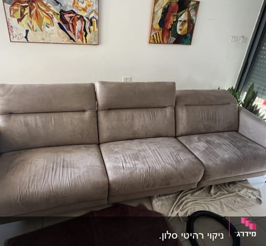 ספה עם כתמים, צינור שואב אבק ומגבת על הרצפה